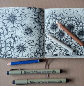 Dessin arabesques sur carnet avec crayons utilisés
